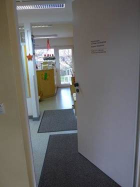 Auf dem Bild ist die geöffnete Eingangstür und der Eingangsbereich der Krankengymnastikpraxis Susanne Schumacher abgebildet.